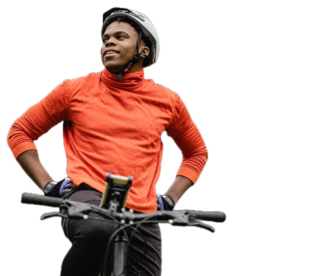 A man taking a break on his bike. It looks like he is riding in the woods.