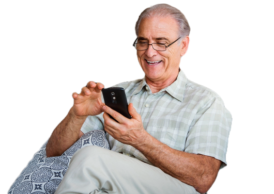 A man smiling while looking at his phone.