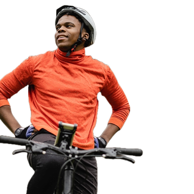 A man taking a break on his bike. It looks like he is riding in the woods. 
