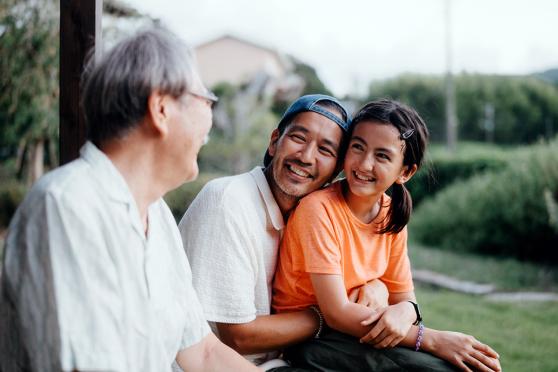 Grandfather, dad, and daughter sitting outside